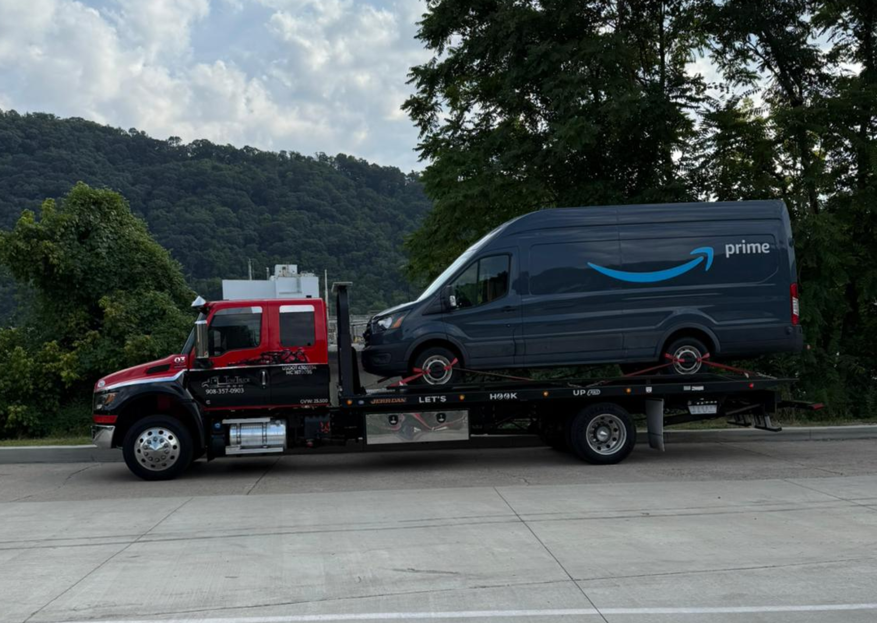 Flatbed tow truck loading a luxury AWD car in New Jersey