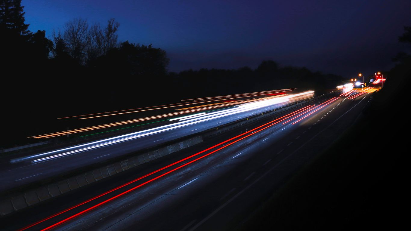 a long exposure photo of a highway at night